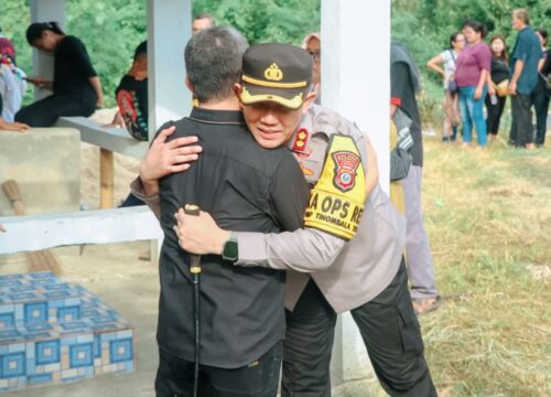 Kapolres Banggai, AKBP Putu Hendra Binangkari saat memeluk Ketua KPU Banggai Santo Gotia yang sedang berduka_OKK