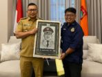 Bupati Banggai, H. Amirudin (kiri) saat menerima cenderamata berupa karya seni sketsa